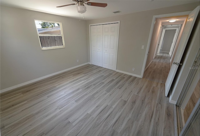 unfurnished bedroom featuring ceiling fan, a closet, and light hardwood / wood-style floors