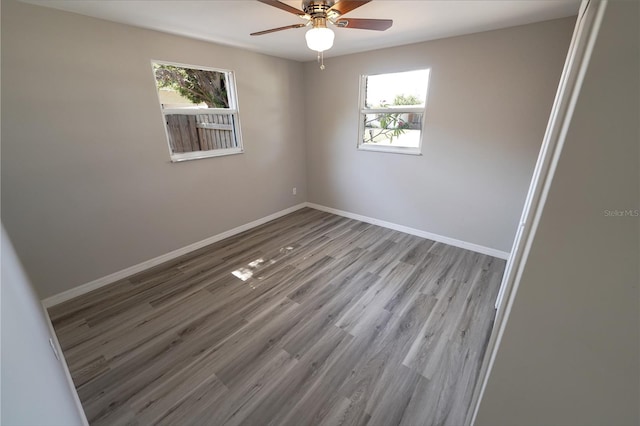 empty room with ceiling fan, a healthy amount of sunlight, and light hardwood / wood-style floors