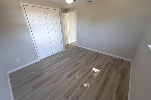 unfurnished bedroom with a closet and wood-type flooring