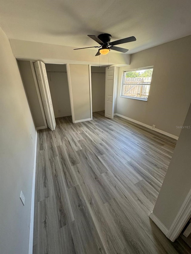 unfurnished bedroom featuring wood-type flooring and ceiling fan