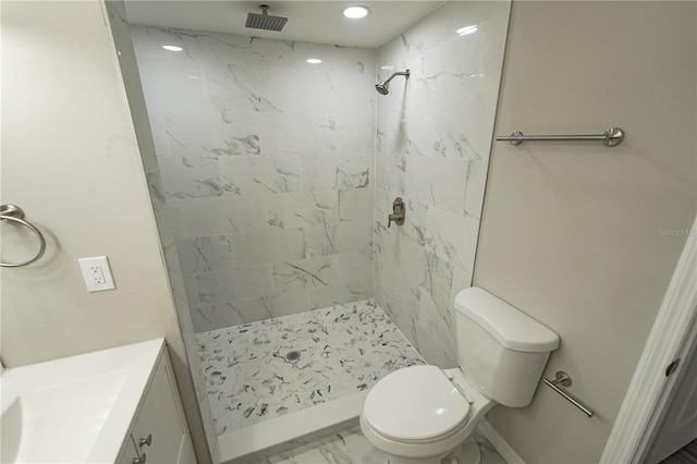 bathroom featuring toilet, a tile shower, and vanity