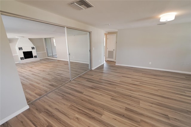 interior space featuring hardwood / wood-style flooring and a brick fireplace