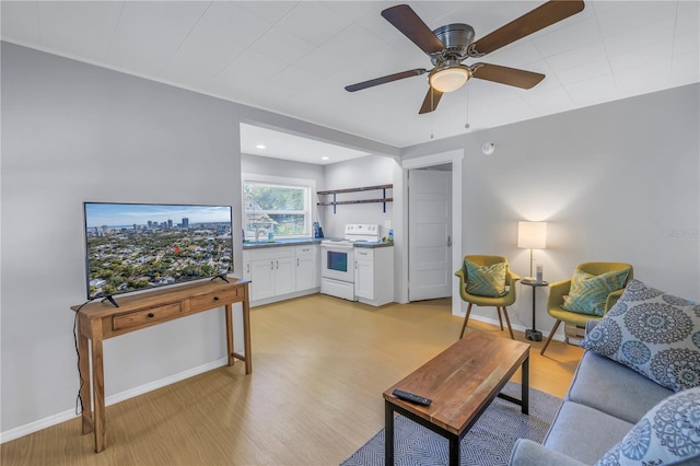 living room featuring ceiling fan, sink, and light hardwood / wood-style floors