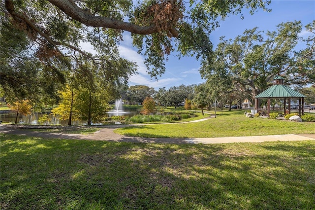 view of home's community with a gazebo, a water view, and a lawn