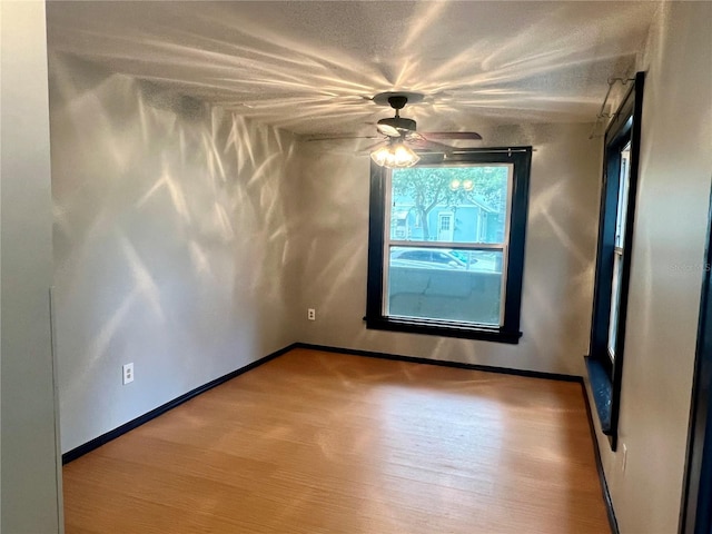 unfurnished room featuring a textured ceiling, light hardwood / wood-style flooring, and ceiling fan