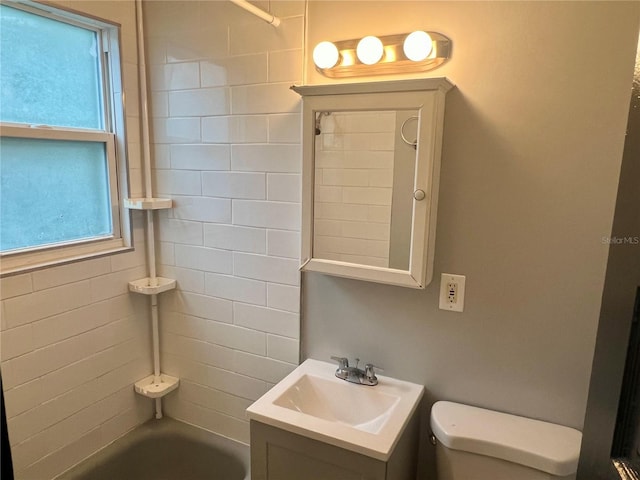 full bathroom featuring toilet, vanity, and tiled shower / bath