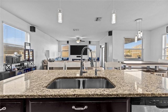 kitchen with dishwasher, hanging light fixtures, sink, and a wealth of natural light