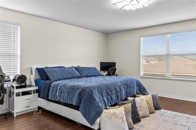 bedroom with a textured ceiling and dark hardwood / wood-style flooring