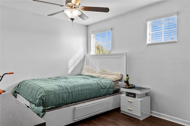 bedroom with ceiling fan, dark wood-type flooring, and multiple windows