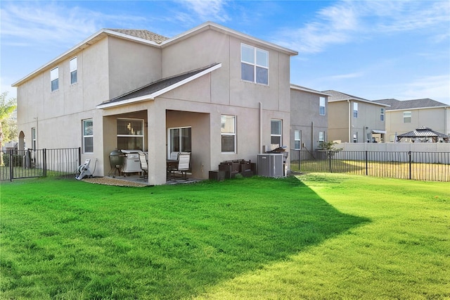 back of property featuring a lawn and central AC unit