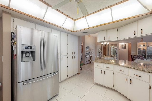 kitchen featuring white cabinetry, light tile patterned floors, light stone counters, and stainless steel refrigerator with ice dispenser