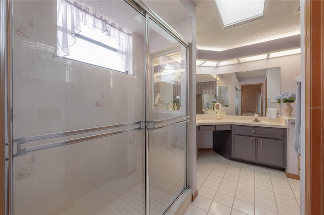 bathroom with tile patterned flooring, a textured ceiling, vanity, and walk in shower