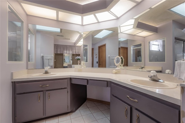 bathroom with tile patterned flooring, vanity, and a skylight