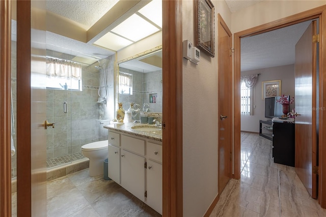 bathroom featuring a textured ceiling, vanity, toilet, and an enclosed shower