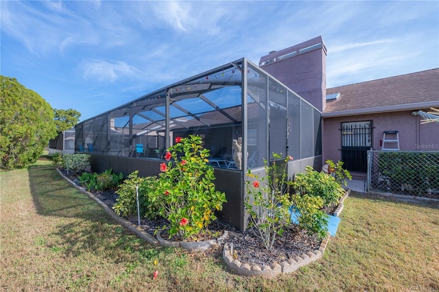 view of side of home featuring a lanai and a lawn