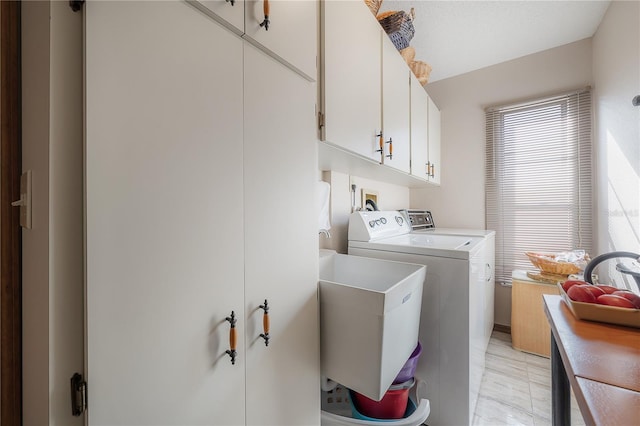 laundry area with cabinets, washer and dryer, and sink