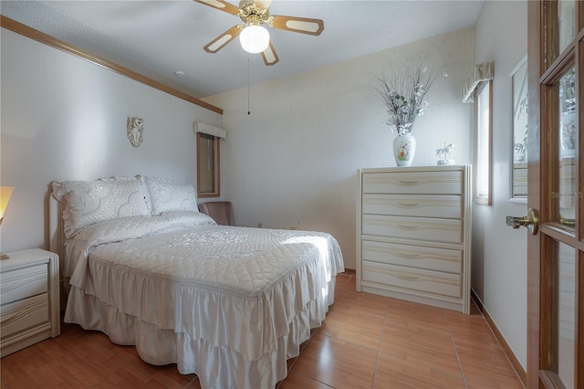 bedroom featuring light hardwood / wood-style floors, ceiling fan, and ornamental molding