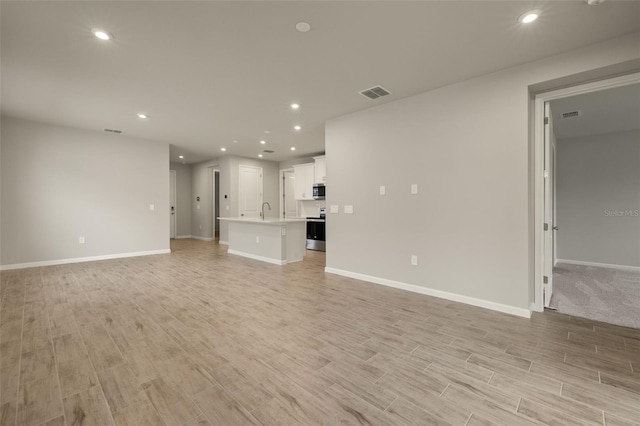 unfurnished living room featuring sink