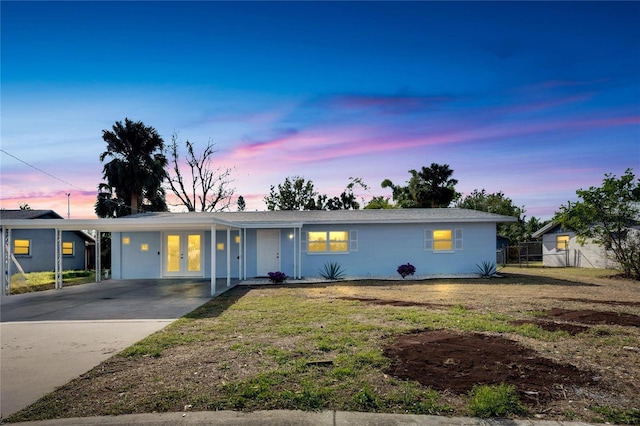 ranch-style house with french doors, a yard, and a carport