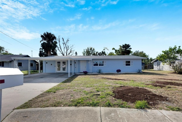 ranch-style home with a carport, a front yard, and french doors