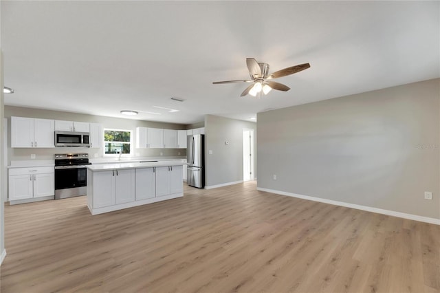 kitchen featuring white cabinets, ceiling fan, light hardwood / wood-style floors, and appliances with stainless steel finishes