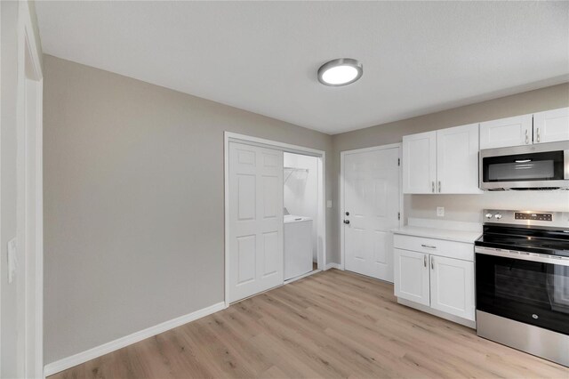 kitchen featuring white cabinets, light hardwood / wood-style floors, washer / dryer, and appliances with stainless steel finishes