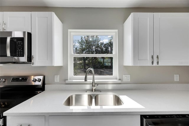 kitchen featuring light stone countertops, sink, white cabinets, and appliances with stainless steel finishes