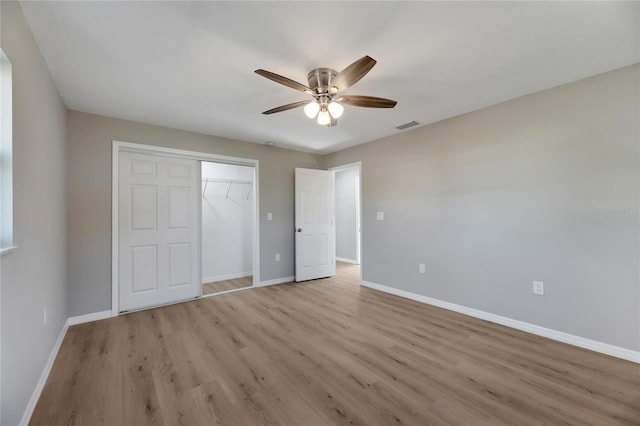 unfurnished bedroom featuring a closet, light hardwood / wood-style flooring, and ceiling fan