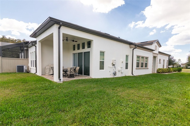 rear view of property with ceiling fan, a lanai, a yard, central AC unit, and a patio area