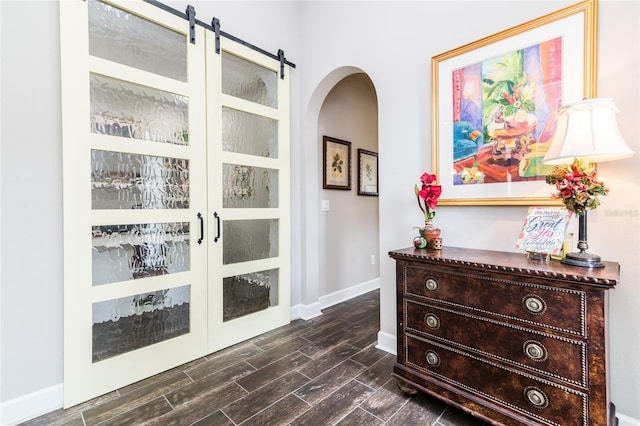 interior space featuring a barn door, french doors, and dark hardwood / wood-style floors