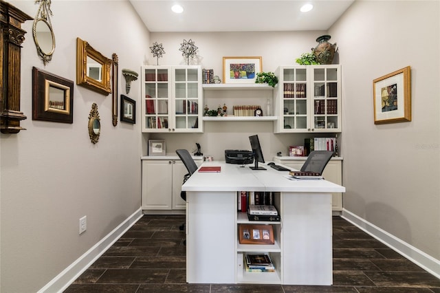 home office featuring dark hardwood / wood-style floors and built in desk