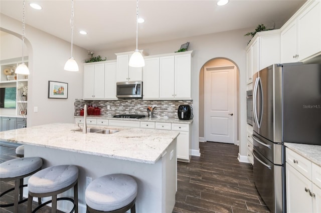 kitchen with sink, dark hardwood / wood-style floors, pendant lighting, white cabinets, and appliances with stainless steel finishes