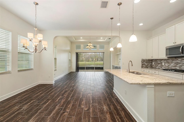 kitchen featuring sink, an inviting chandelier, tasteful backsplash, dark hardwood / wood-style floors, and white cabinets