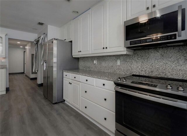 kitchen featuring white cabinets, appliances with stainless steel finishes, light wood-type flooring, and light stone countertops