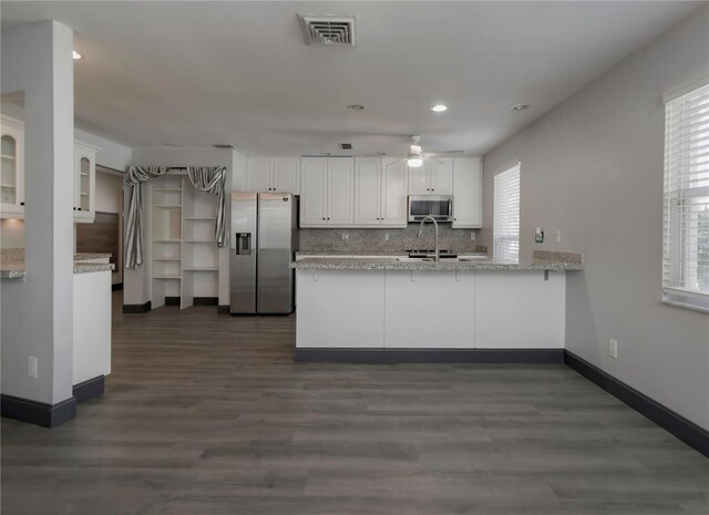 kitchen featuring kitchen peninsula, white cabinetry, dark hardwood / wood-style floors, and appliances with stainless steel finishes