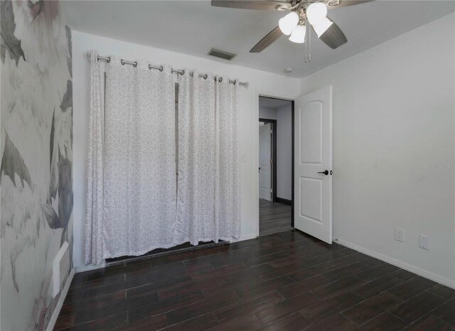 interior space with ceiling fan and dark wood-type flooring