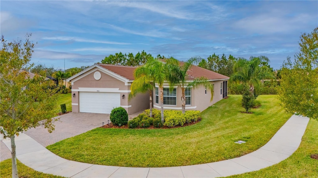 ranch-style home with a garage and a front lawn