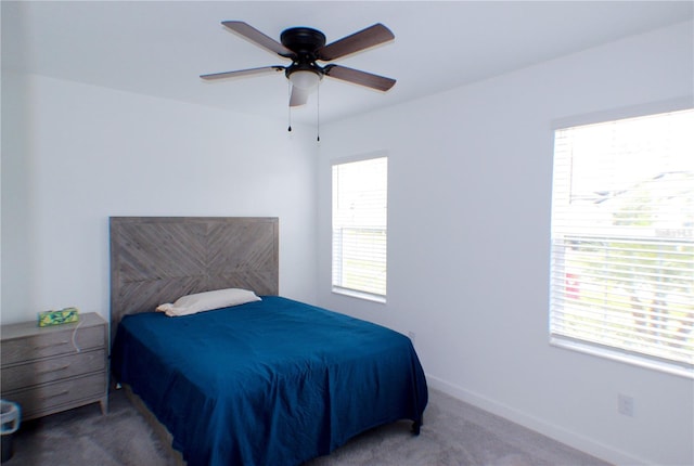 bedroom with ceiling fan, carpet floors, and multiple windows