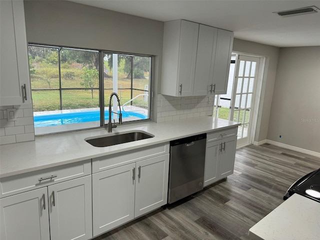 kitchen with a wealth of natural light, white cabinetry, and stainless steel dishwasher