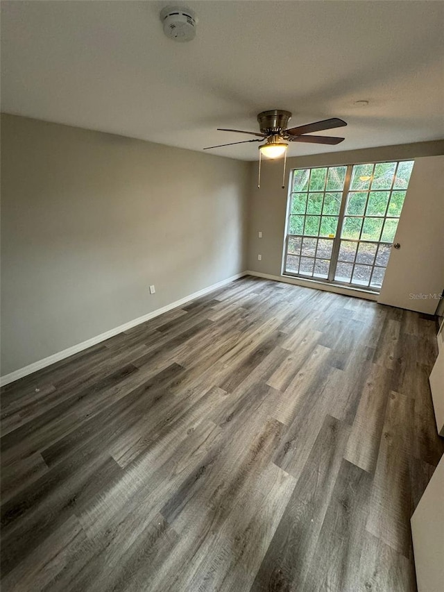 unfurnished room with ceiling fan and dark hardwood / wood-style flooring