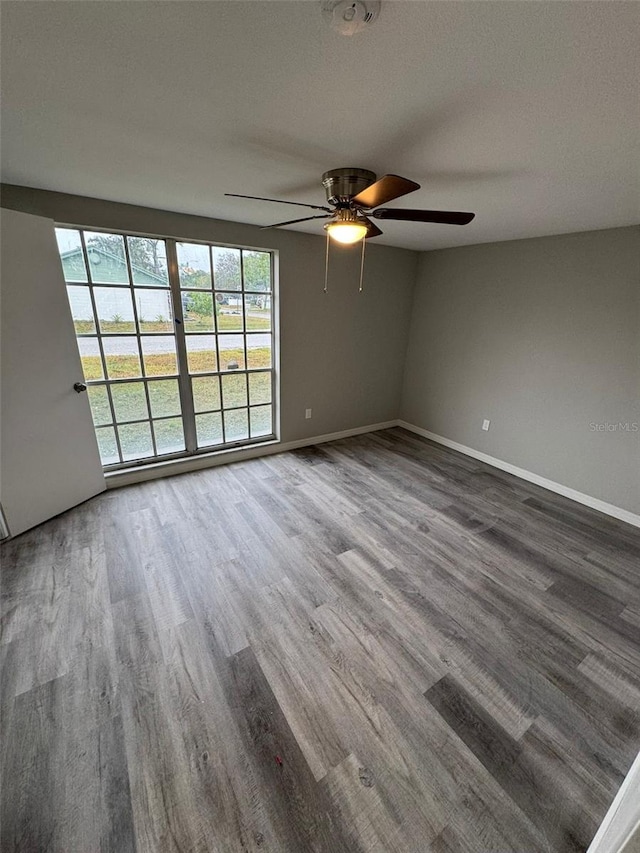 unfurnished room with ceiling fan, wood-type flooring, and a textured ceiling