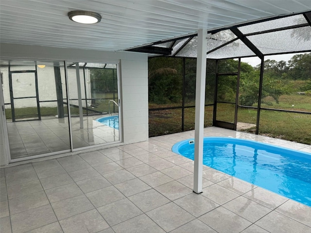 view of swimming pool featuring a patio and glass enclosure