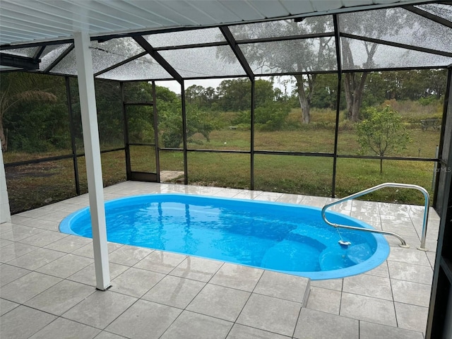 view of swimming pool featuring a lawn, a lanai, and a patio