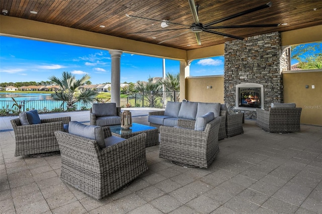 view of patio featuring ceiling fan and an outdoor living space with a fireplace