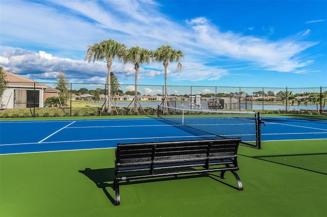 view of tennis court with a water view