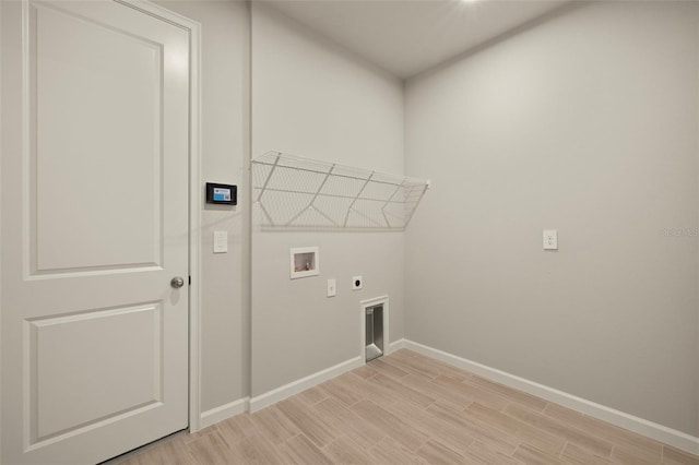 washroom with hookup for an electric dryer, light hardwood / wood-style floors, and hookup for a washing machine