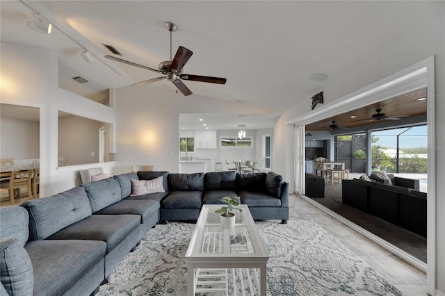 living room with rail lighting and vaulted ceiling