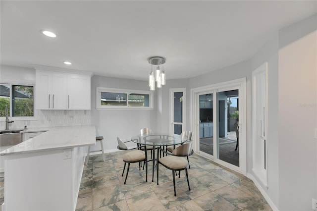 dining area featuring sink and a chandelier