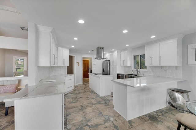 kitchen featuring backsplash, kitchen peninsula, white cabinetry, and range hood