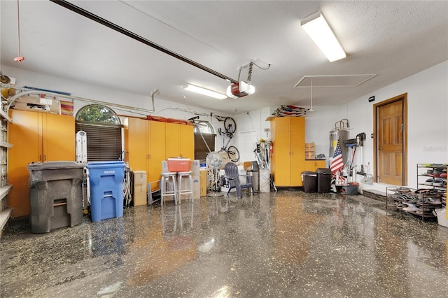 garage featuring strapped water heater and a garage door opener